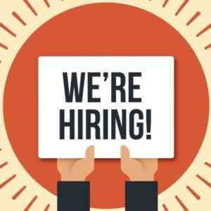 Some one holding up a sign writing "we're hiring" for UASC's b2b sales representative position