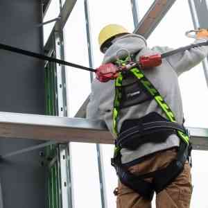 Worker using fall protection gear as a safety precaution he learned in em 385 training
