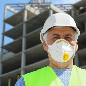 Builder in safety equipment at construction site